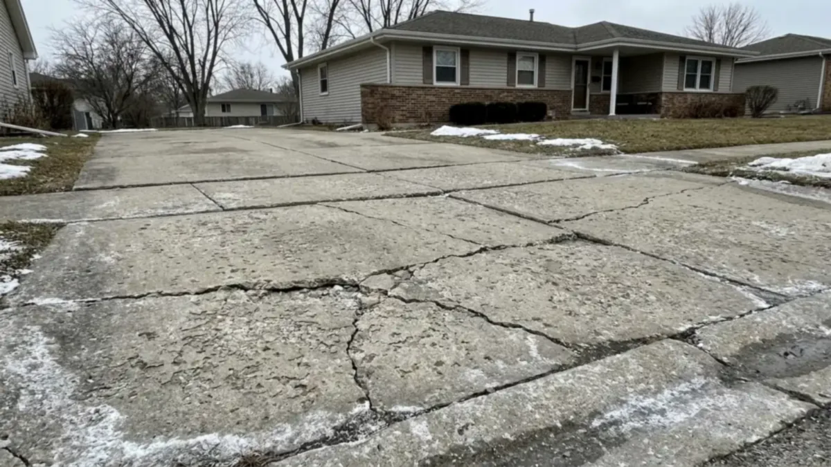 Freeze-thaw damaged concrete driveway in Joliet Illinois Will County salt scaling cracking heaving deicing damage spring